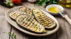 Fette di melanzane grigliate con olio e erbe aromatiche servite su un piatto